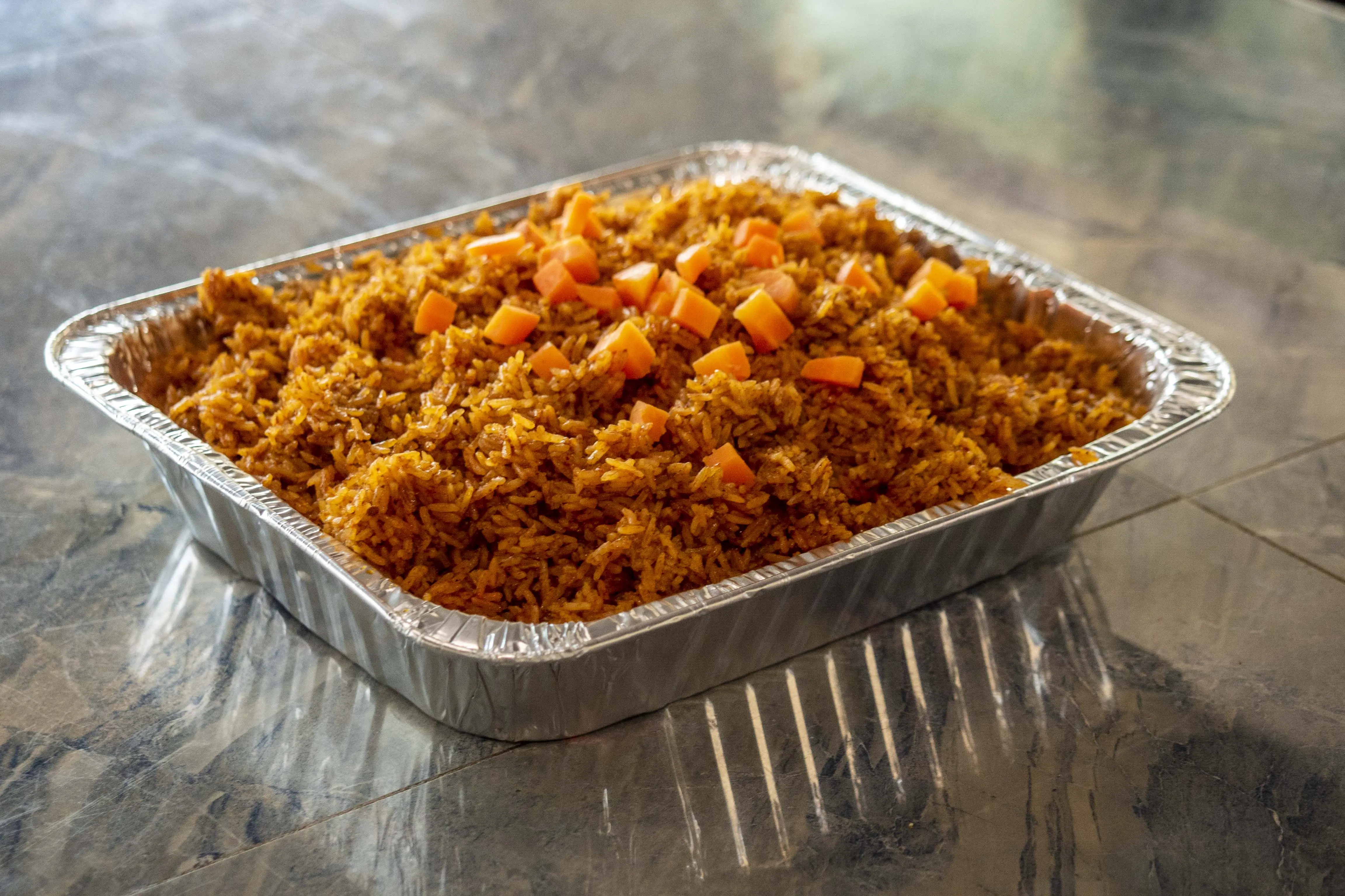 Large party-size jollof rice catering tray — Diamonds & Pearls Catering Accra